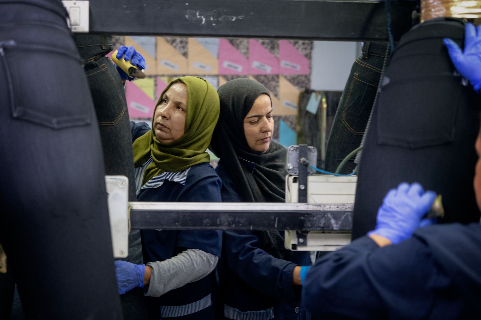 Mujeres tunecinas retocan prendas de mezclilla.