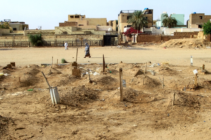 A woman walks by a makeshift cemetery.