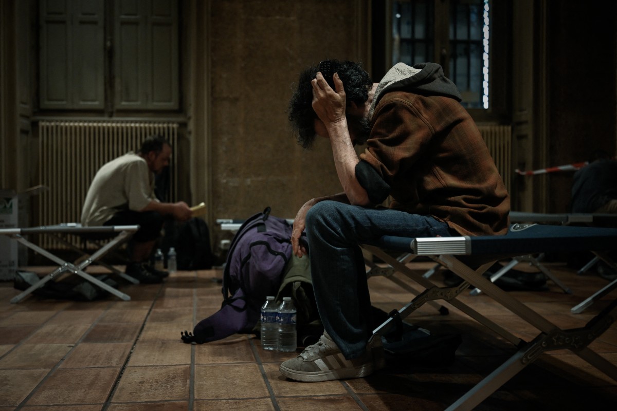 A man sitting on a cot