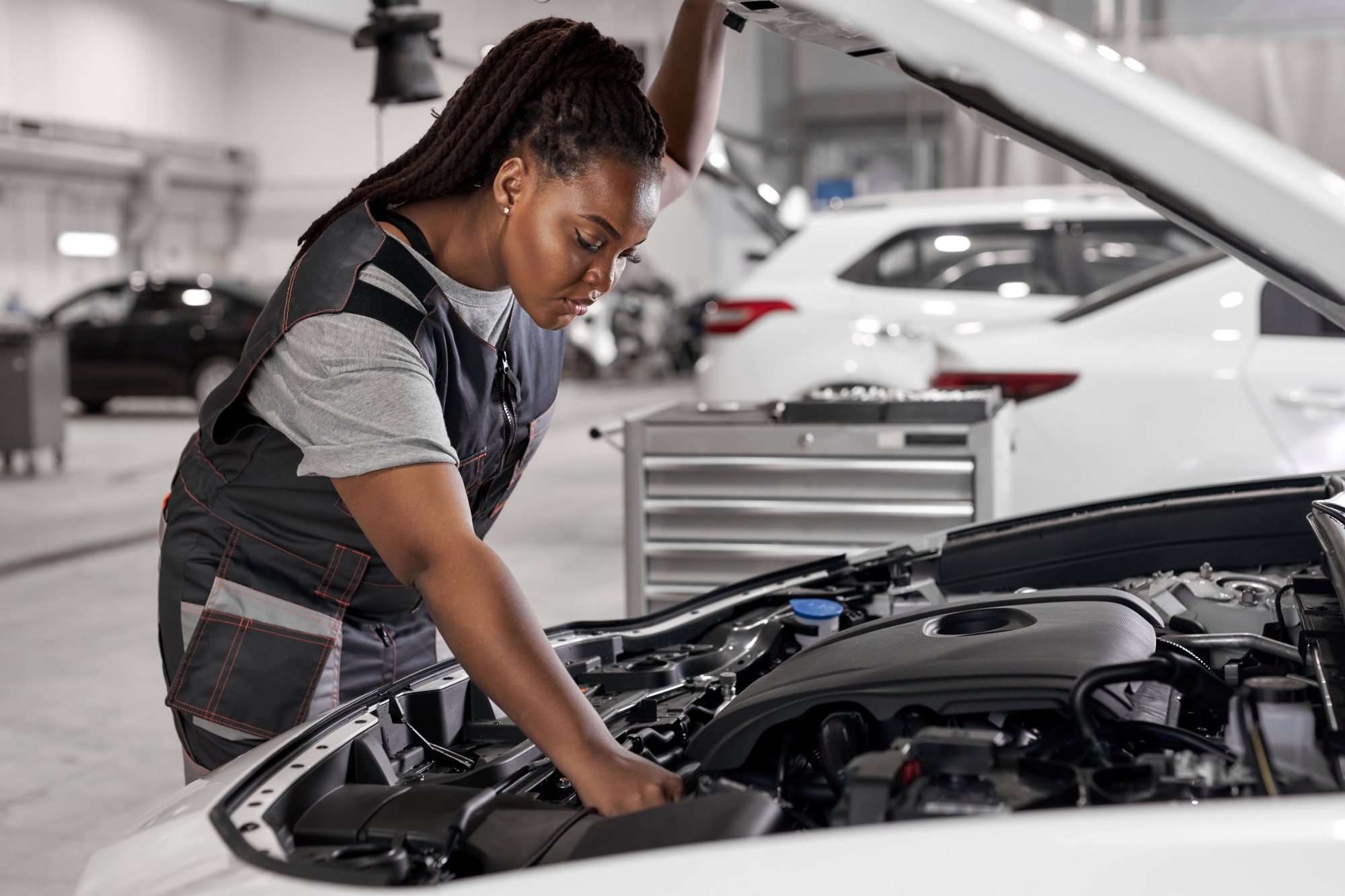 A female vehicle inspector assesses the engine of a vehicle