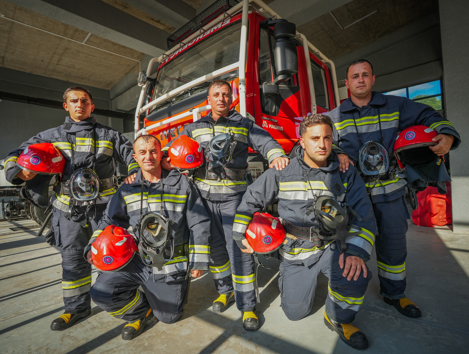 Firefighters posing in front of a fire truck