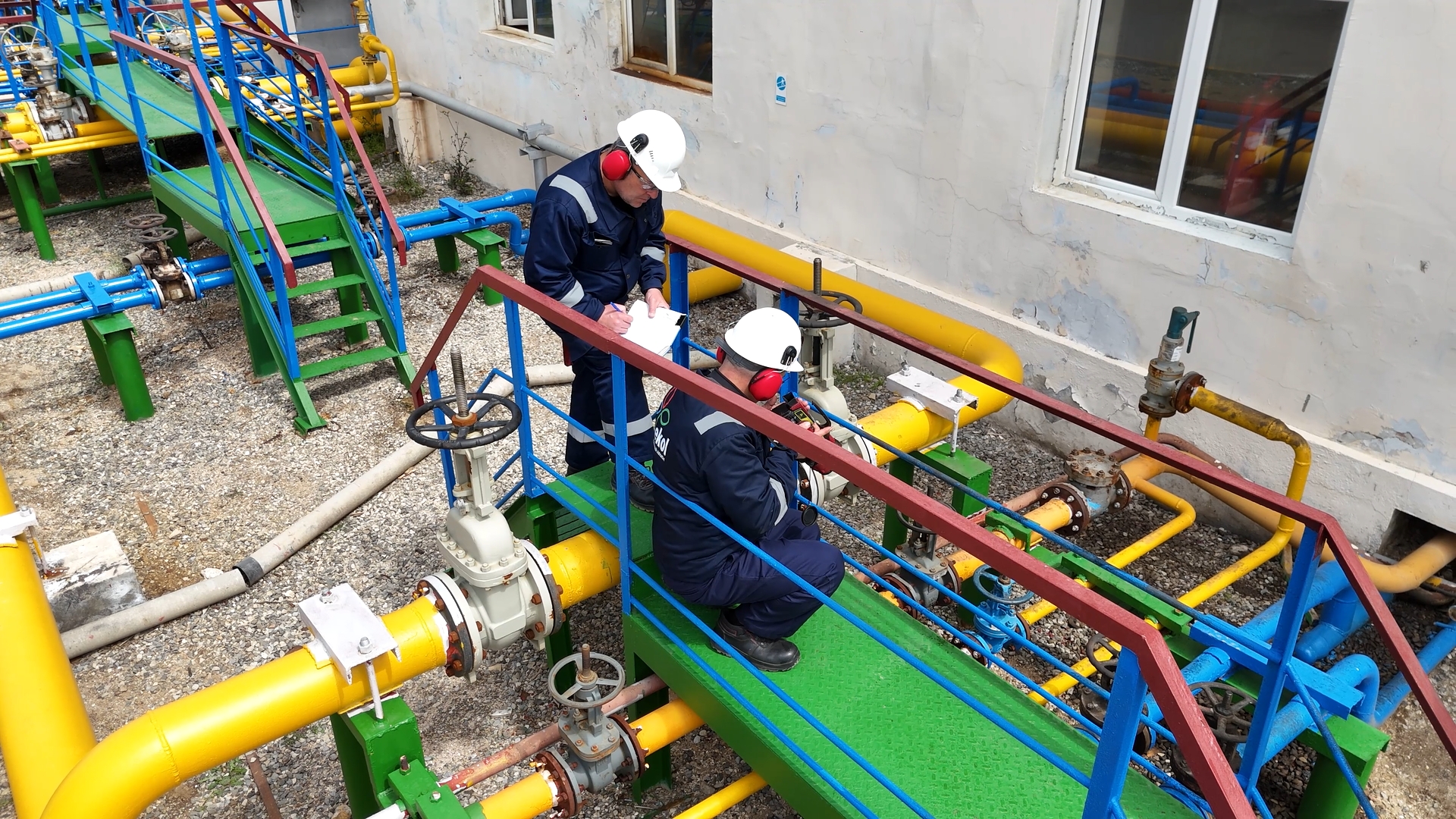 Two people work on some pipes