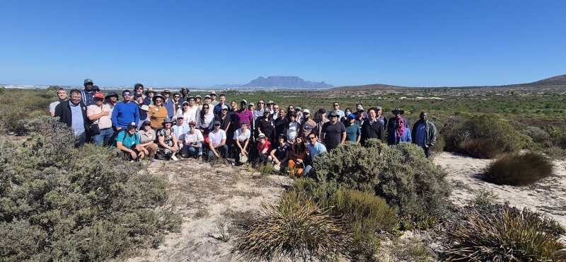 Attendees of a Generation Restoration project workshop at Blaauwberg Nature Reserve, Cape Town, surrounded by restored native fynbos vegetation.&nbsp;