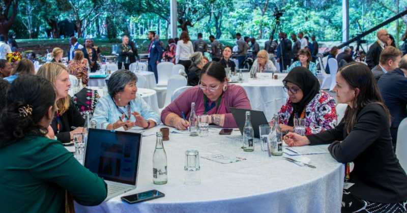 A group of people sitting around a round table</p>
<p>AI-generated content may be incorrect.