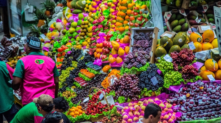 Colourful fruits displayed in a Brazilian marketplace, including strawberries, grapes and oranges. 