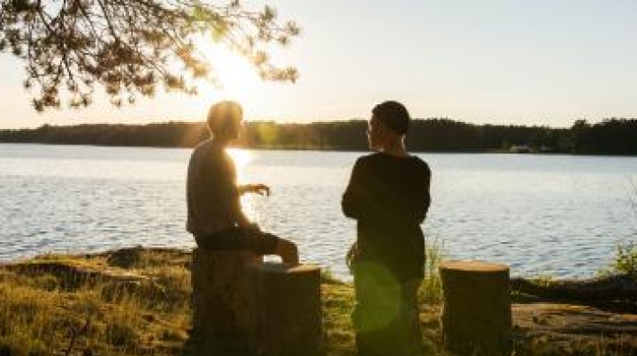 two people seatted by a river