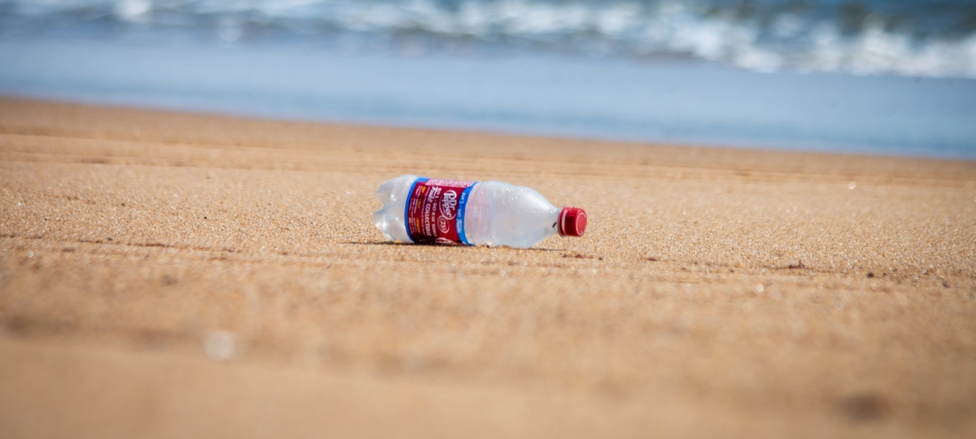 A plastic soda bottle found littered right near the ocean.