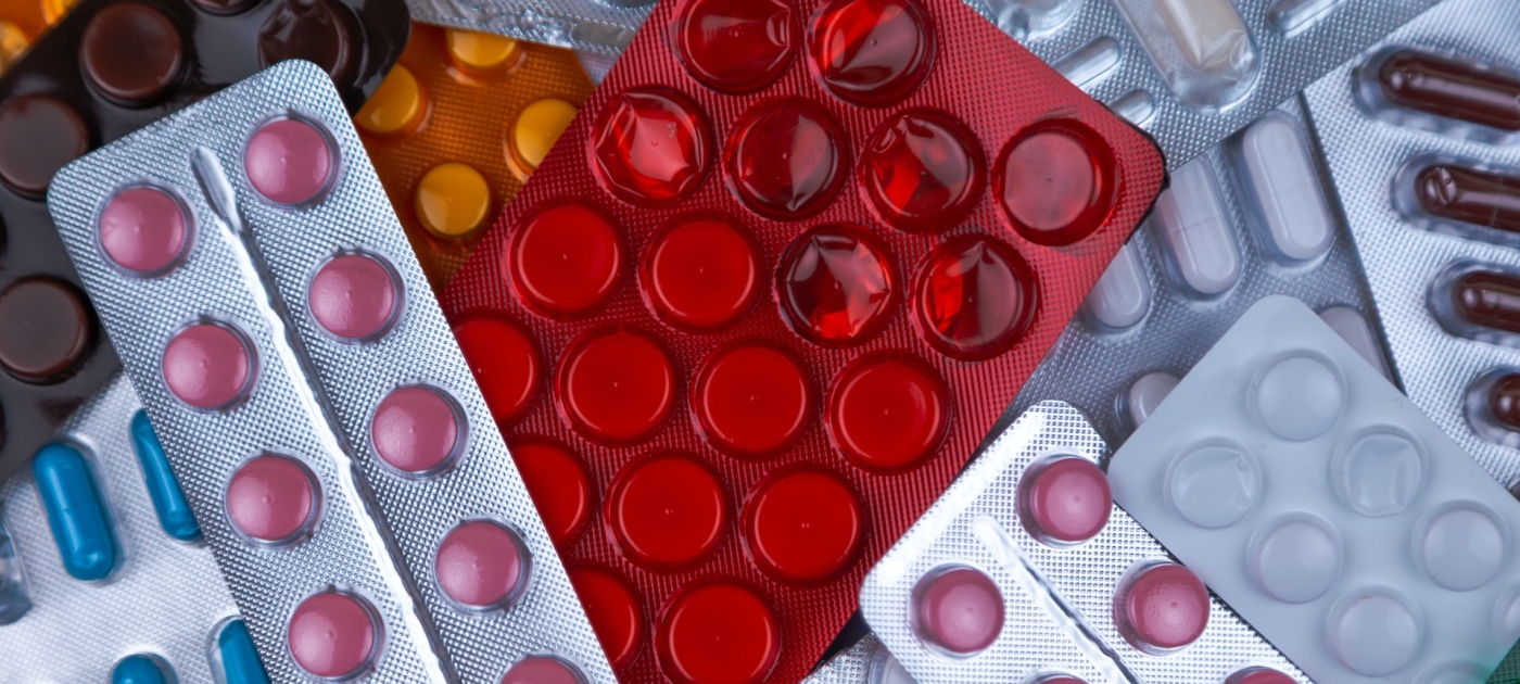 pile of blister packs of colorful medicine tablets
