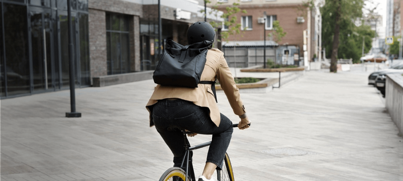 Young adult cycling to work in the city