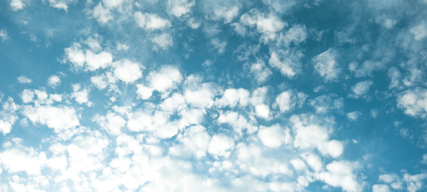 Light white clouds pepper a deep blue sky