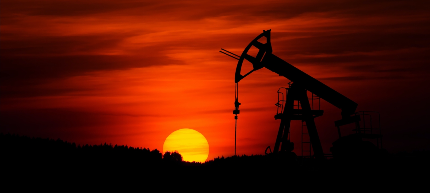 Photo of sunset behind an oil field