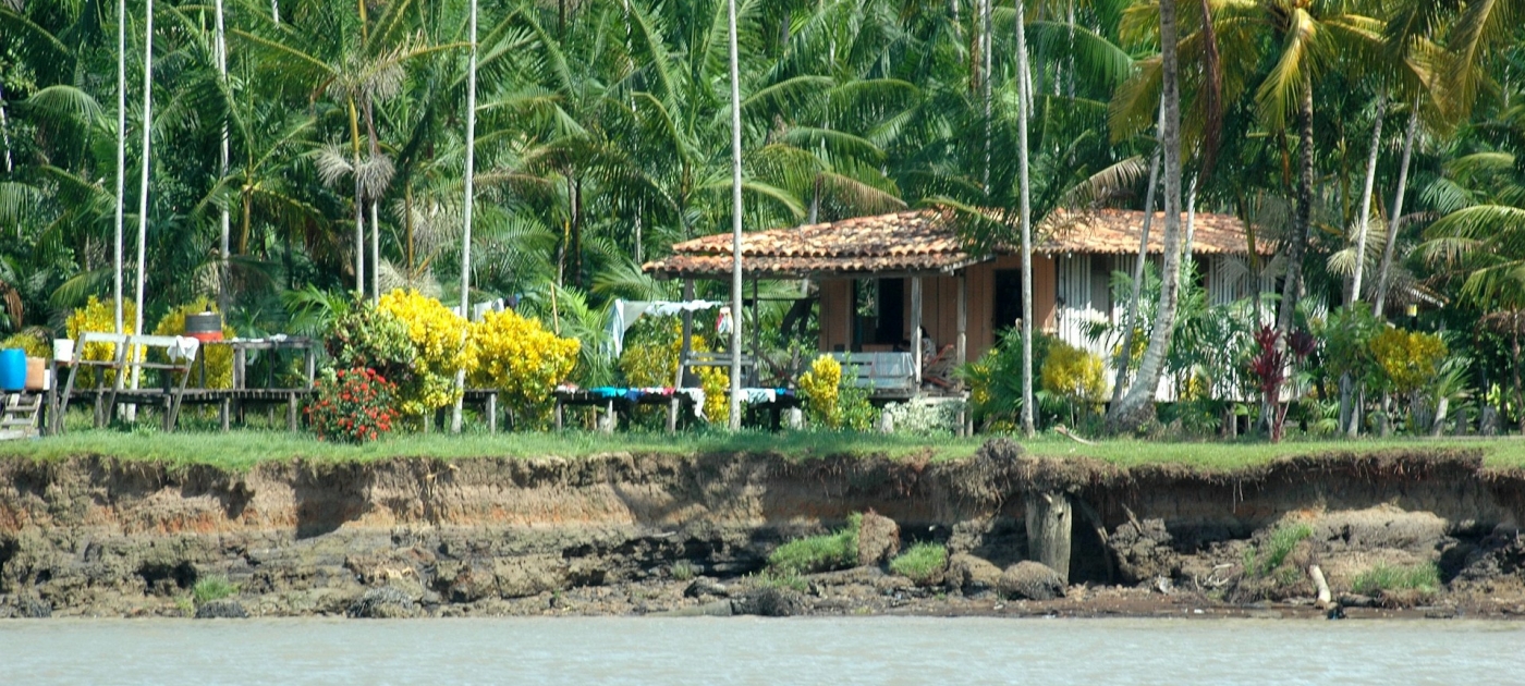 Brown and white wooden house near body of water during daytime
