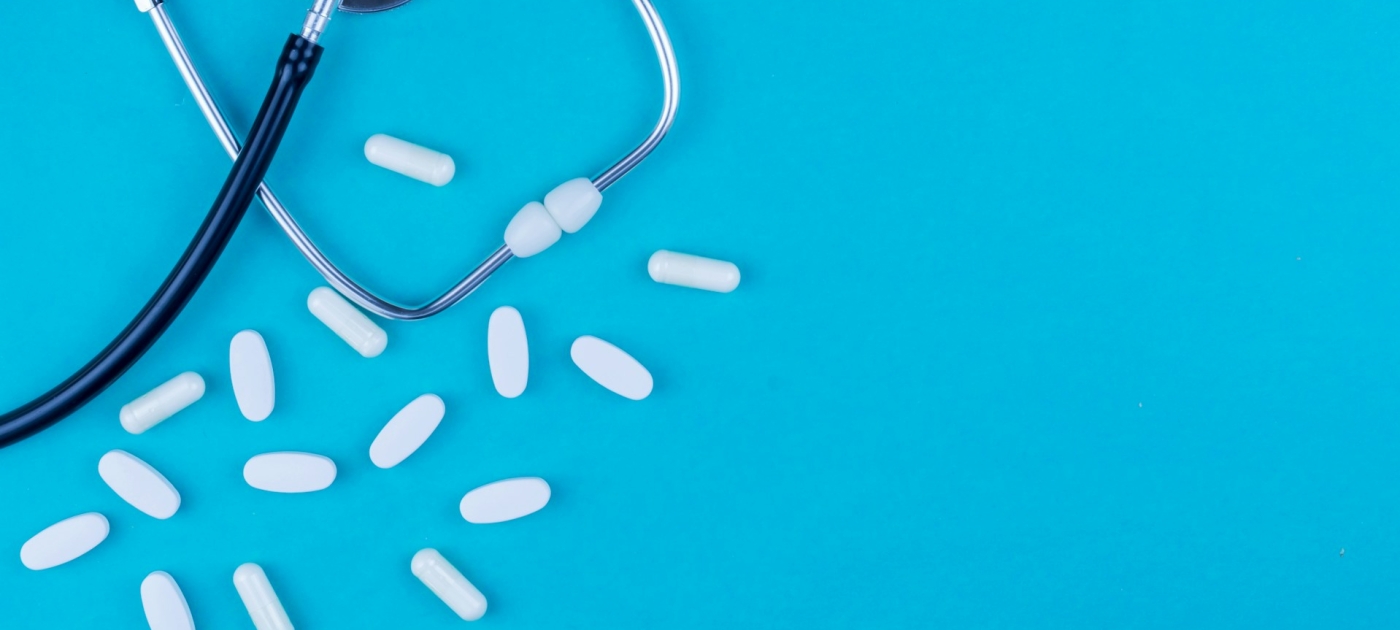 Stethoscope with capsules on a blue background