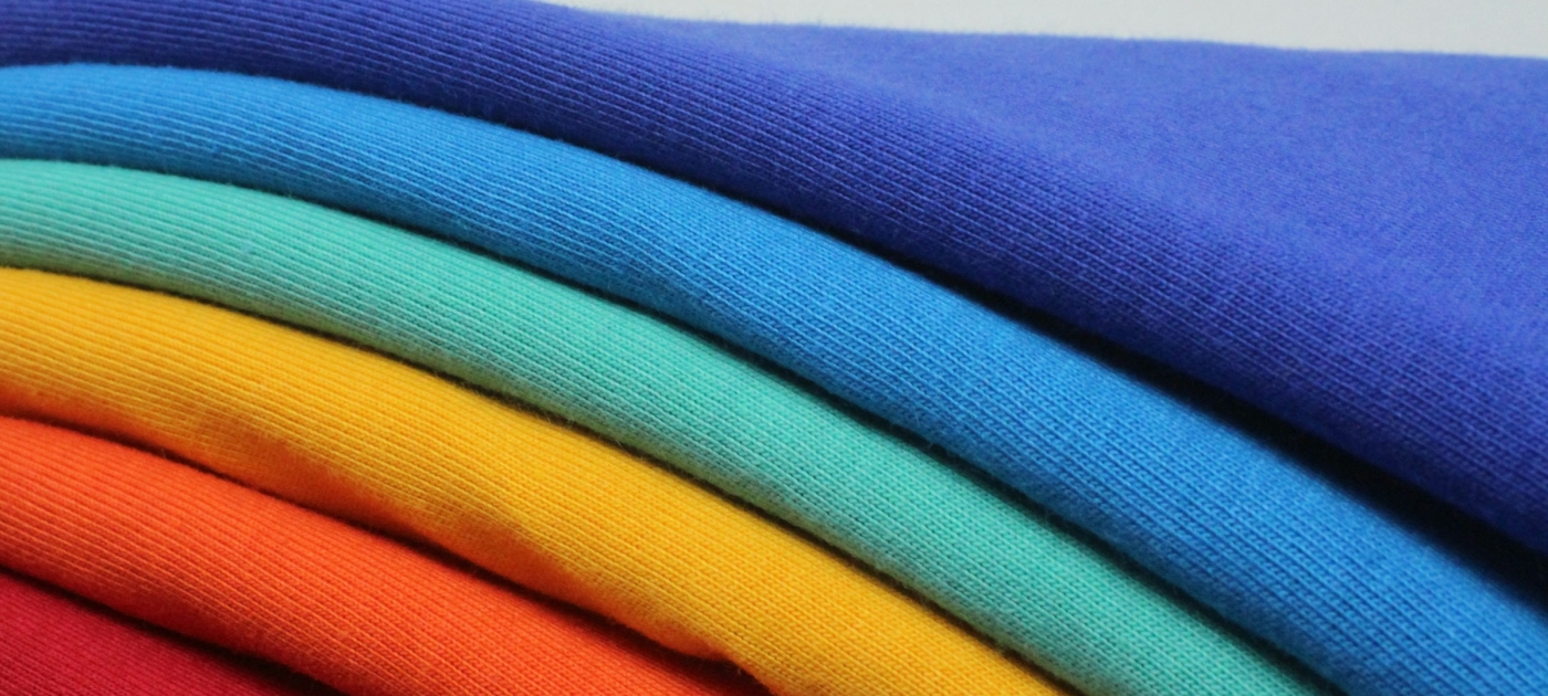 A stack of different colored t-shirts sitting on top of each other