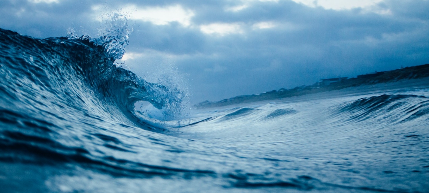 Ocean wave under a cloudy sky