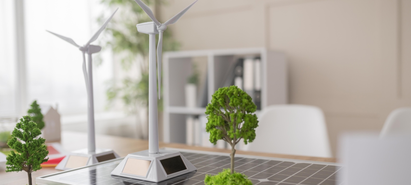 Models of wind turbines, trees and a solar panel on a table