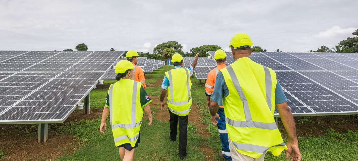 People walking next to solar panels