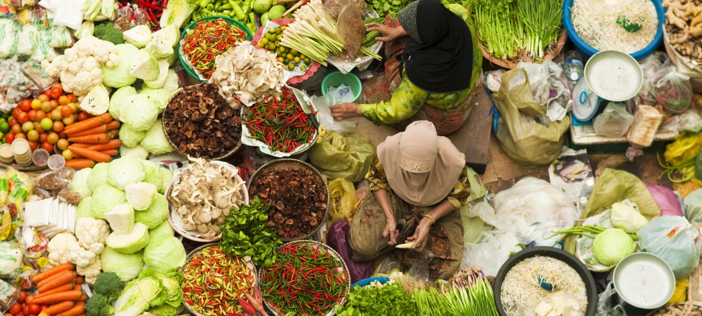 Dos vendedoras rodeadas de vegetales
