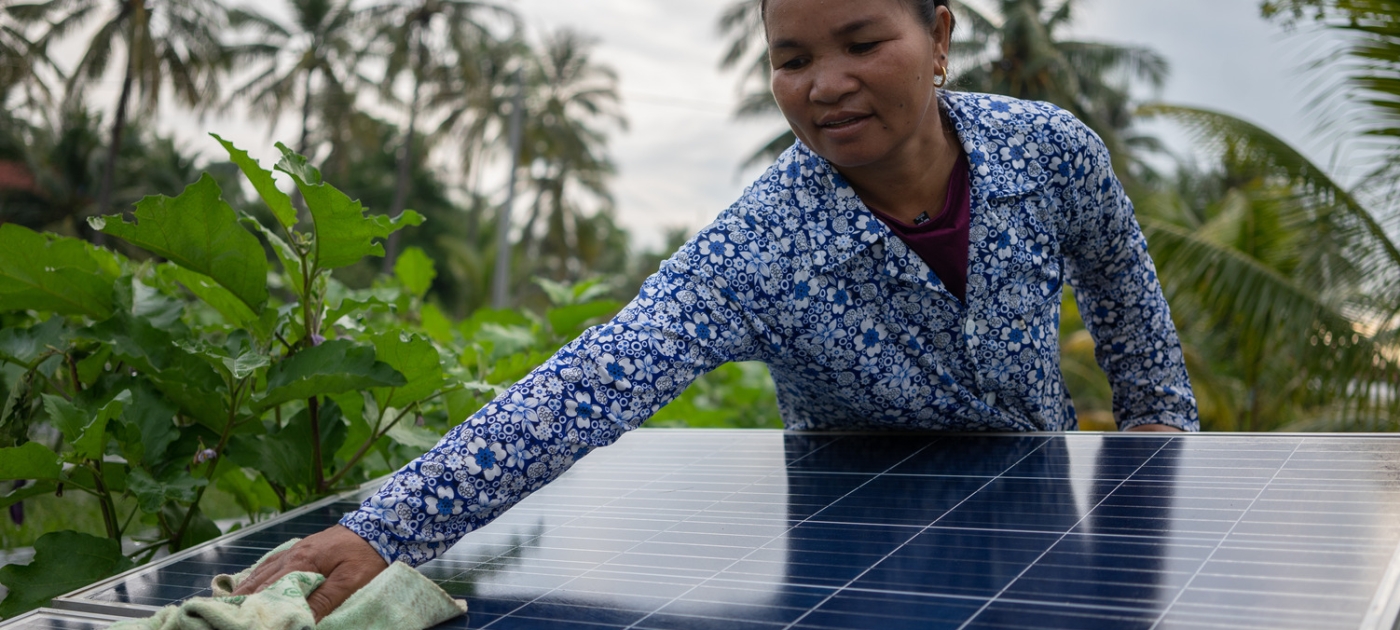 A woman is cleaning a solar panel in a farm