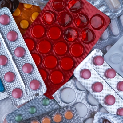 pile of blister packs of colorful medicine tablets
