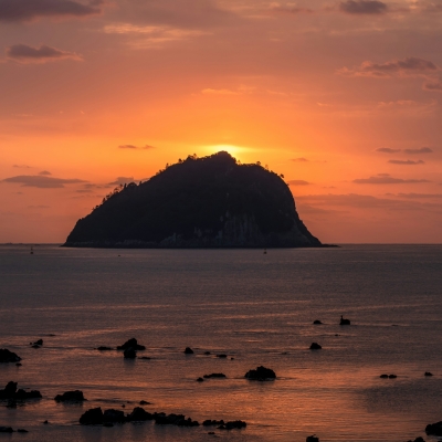 Silhouette of island on sea during sunset
