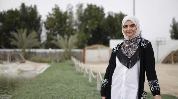 A woman stands in front of the camera