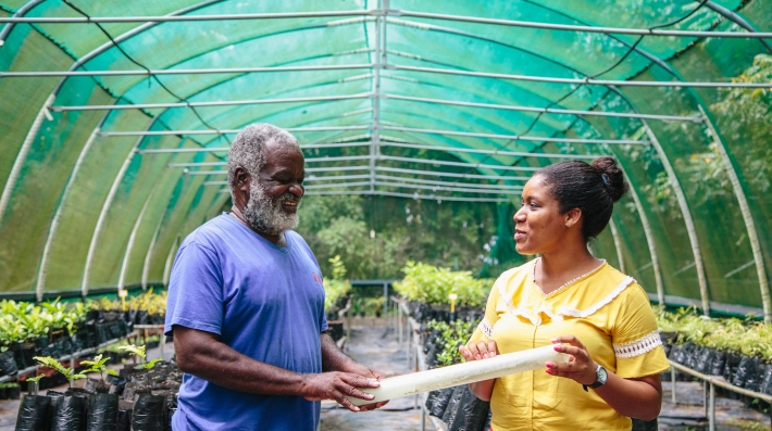 Two people pose for a picture in an ecological restoration project