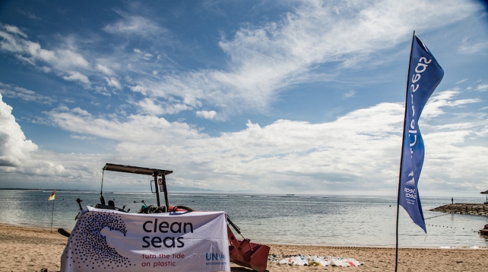 A banner with the Clean Seas campaign on a beach, with plastic waste gathered in a pile.