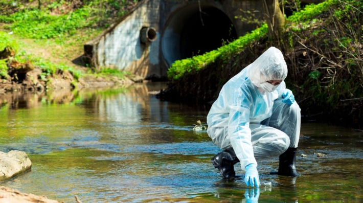 A female scientist takes a water sample