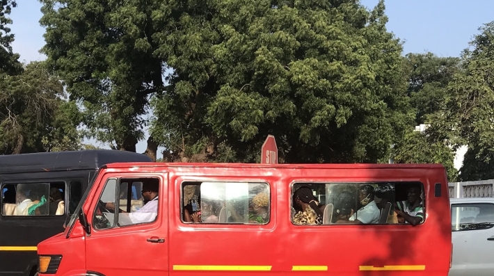 A red minibus filled with passengers