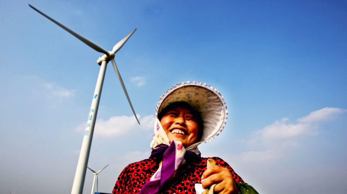 A woman poses with a windmill