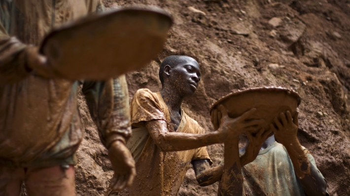 A man holding a pan full of mud