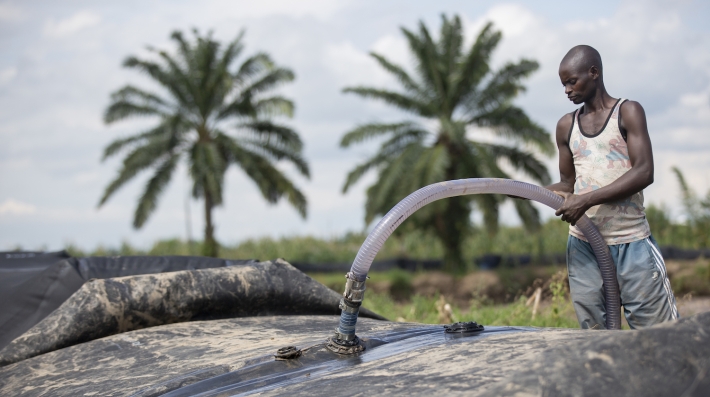 A man stands beside a portable dam segment