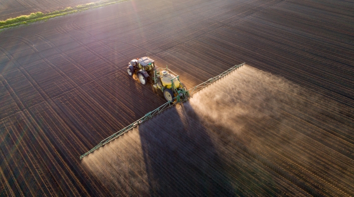 A tractor spraying fertilizer