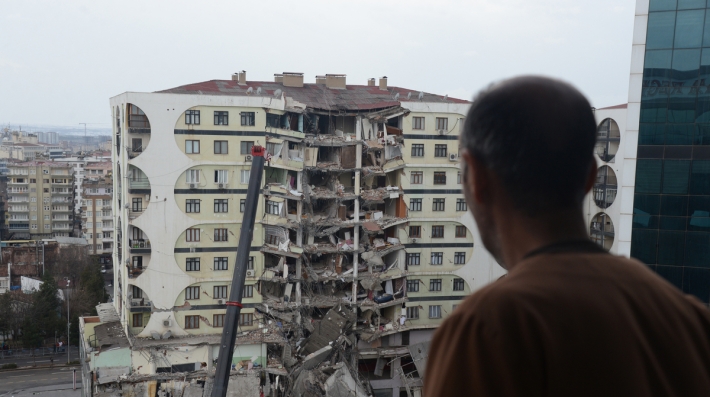 Man viewing the after effects of a natural disaster on a building