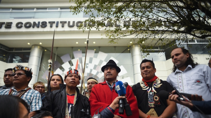 People protest in front of a courtroom.