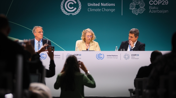 Three people seated on a stage, participating in a panel discussion.