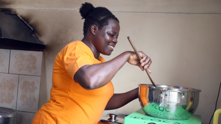 A woman cooking food in a pot.