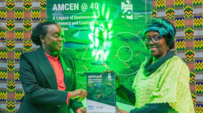 Kenyan Cabinet Secretary for the Environment, Deboarh Barasa, and UNEP Deputy Executive Director Elizabeth Mrema both hold a copy of the AMCEN @40 report, standing in front of a sign of the same book
