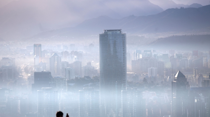  A person stands on a hill overlooking a haze-shrouded city 