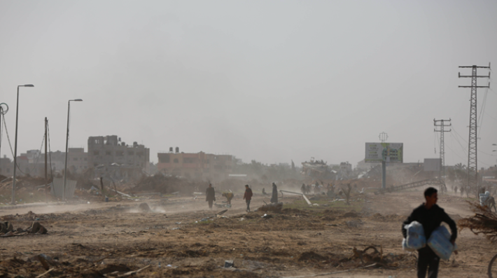 Palestinians walk amid the destruction in the Al Matahin and Al Qarara areas in northern Khan Younis