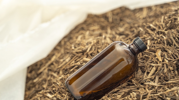 Botella de aceite esencial sobre corteza de cascarilla