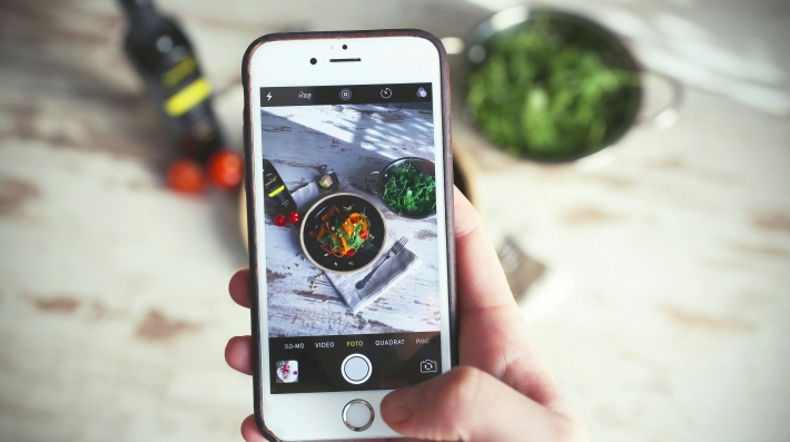 Una persona fotografía su comida con su celular.