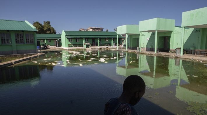 A child walks in front of a flooded school 