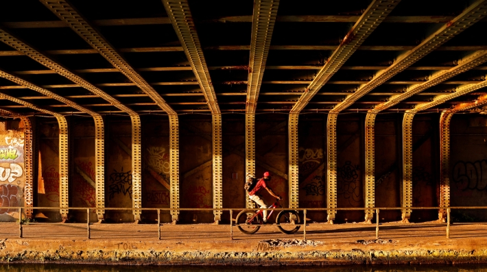A person is cycling alongside a river