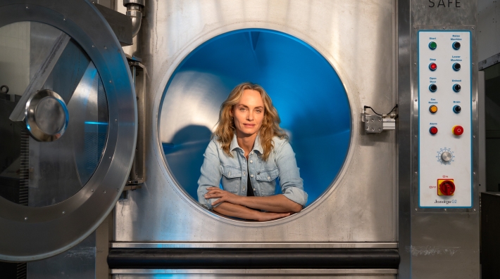 A woman posing in an industrial washing machine.