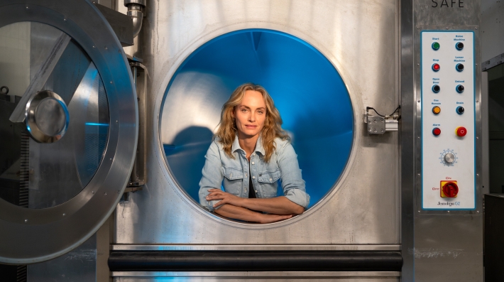 A woman posing in an industrial washing machine.