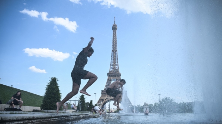 People jumping into a pool in front of the Eiffel Tower