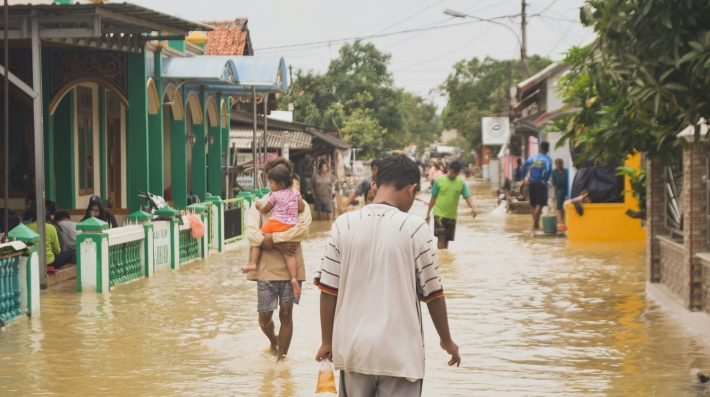 A man walking down a flooded street