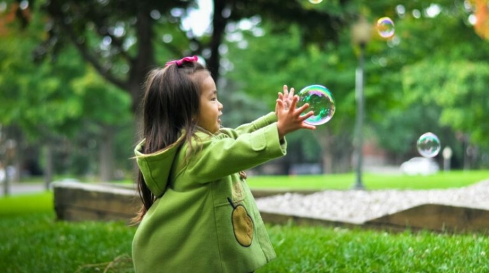 child running after a soap bubble
